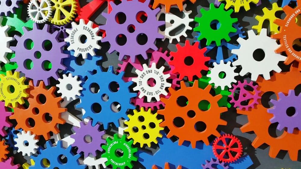 Colorful interlocking gears symbolizing diversity and teamwork in a vibrant mechanical design.